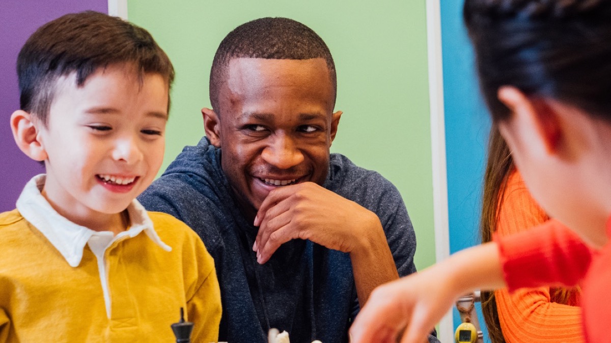 A teacher enjoying a chess activity with children